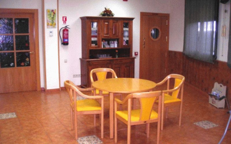 Salón social con mesas redondas y sillas